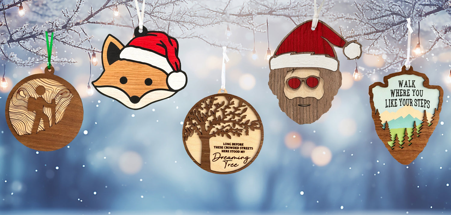Wooden Christmas ornaments with festive designs against a snowy background